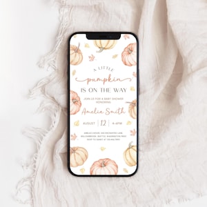 Puede incluir: Un smartphone muestra una invitación a un baby shower con temática de calabaza. La invitación presenta calabazas en acuarela, hojas de otoño y el texto "A Little Pumpkin is on the Way". La fecha es el 12 de agosto, 4-6 PM.