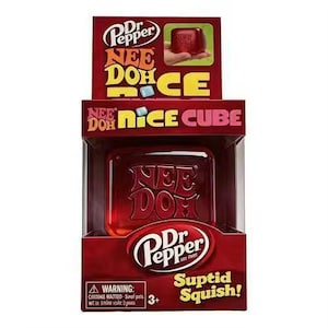 May include: A Dr Pepper branded Nee Doh Nice Cube in its original red packaging. The square, translucent red fidget toy features the embossed text Nee Doh on its front surface. The box displays the Dr Pepper logo and the text Nice Cube.