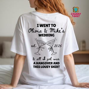 Könnte beinhalten: Weißes T-Shirt mit schwarzem Text und einer Grafik von zwei Martinigläsern. Der Text lautet: „I went to Olivia & Mike's Wedding est. 2025 & all I got was a hangover and this lousy shirt.“