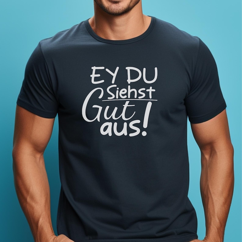 May include: Navy blue t-shirt with white text that reads "EY DU Siehst Gut aus!" in a casual font. The shirt has a crew neck and short sleeves. The text is centered on the chest.