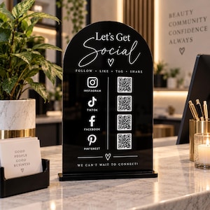 May include: A black arched acrylic sign with white text and icons. The sign reads Let's Get Social, Follow, Like, Tag, Share, and We Can't Wait To Connect. It features Instagram, TikTok, Facebook, and Pinterest logos with four corresponding QR codes.
