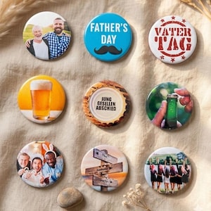 May include: Nine circular pin-back badges featuring various designs: a photo of two men, a blue badge with text FATHER'S DAY and a moustache, a white badge with red text VATER TAG, a beer glass, a badge with text JUNG GESELLEN ABSCHIED, a green bottle, a group photo, a wooden signpost, and a group of people.