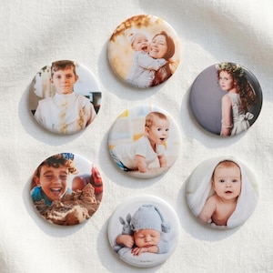 May include: Seven circular photo badges featuring various portraits of children and infants. The images include a child in a white shirt, a person holding a baby, a child in a floral crown, a crawling baby, a laughing child, and a sleeping baby.