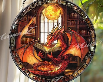 May include: Round stained glass window featuring a red dragon reading a book in a library setting. The dragon has orange wings and is set against a backdrop of bookshelves and a glowing orb. The window is framed in black and hangs from a chain.