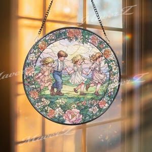 May include: A circular stained glass window with a black metal frame. It features four children holding hands and running in a field, surrounded by pink and white roses. The window is suspended by a chain.
