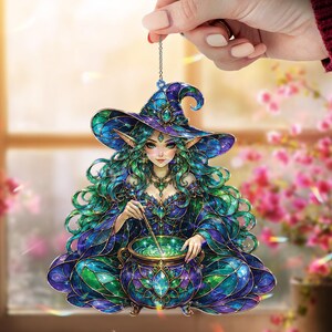 May include: A decorative hanging ornament featuring a fantasy witch with long flowing green hair, wearing a pointed hat and a dark blue and green gown, stirring a glowing cauldron. The design has a stained glass aesthetic with intricate patterns.