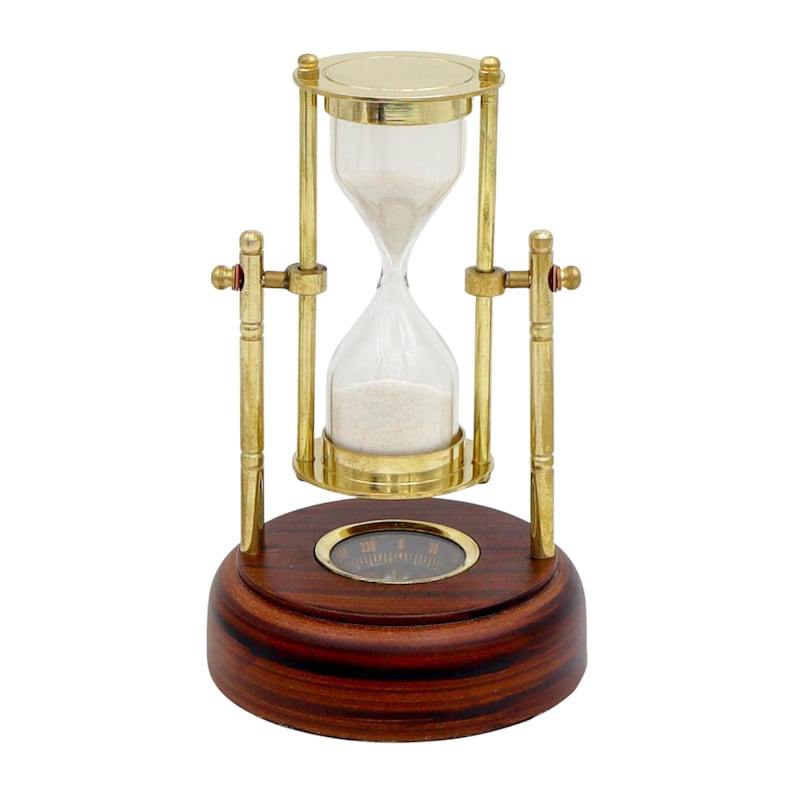 K&ouml;nnte beinhalten: Eine Sanduhr mit Holzsockel und messingfarbenem Metallrahmen. Die Sanduhr enth&auml;lt wei&szlig;en Sand und ein Kompass ist in den Holzsockel eingelassen. Die Sanduhr ist ein dekorativer Gegenstand.