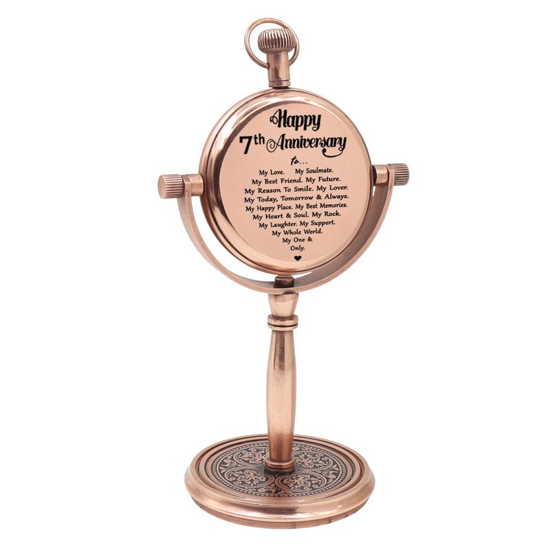 May include: A copper-toned metal desk ornament shaped like a pocket watch on a stand. The circular face features the text: Happy 7th Anniversary to... My Love. My Soulmate. My Best Friend. My Future. My Reason To Smile. My Lover. My Today, Tomorrow & Always.