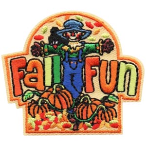 Puede incluir: Parche bordado con temática otoñal. El parche presenta un espantapájaros con peto azul y sombrero azul, rodeado de calabazas naranjas y hojas de otoño. Las palabras "FALL FUN" se muestran prominentemente en naranja y verde.