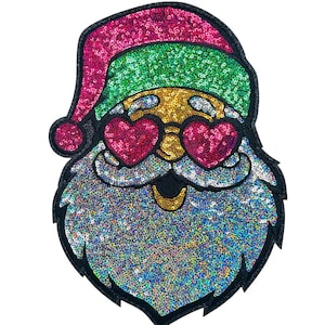 May include: A sequined Santa Claus patch with a black outline. The Santa wears a pink hat, green cap, gold face, heart-shaped pink sunglasses, and a silver beard. A fun, festive design for Christmas.