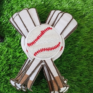 Könnte beinhalten: Baseball-Applikation mit einem Baseball mit roten Nähten, umgeben von weißen und braunen Bändern. Der Baseball hat eine glitzernde Textur. Die Bänder sind weiß mit braunen Rändern und einem braunen Sockel.