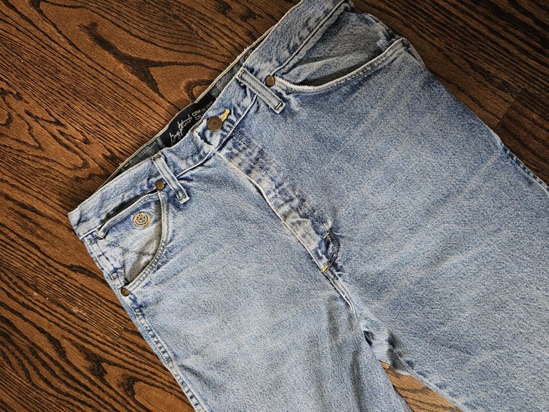 May include: Light blue denim jeans with a classic five-pocket design. The jeans feature a button and zipper closure, belt loops, and rivets. The jeans are made of a durable denim fabric and have a faded wash.