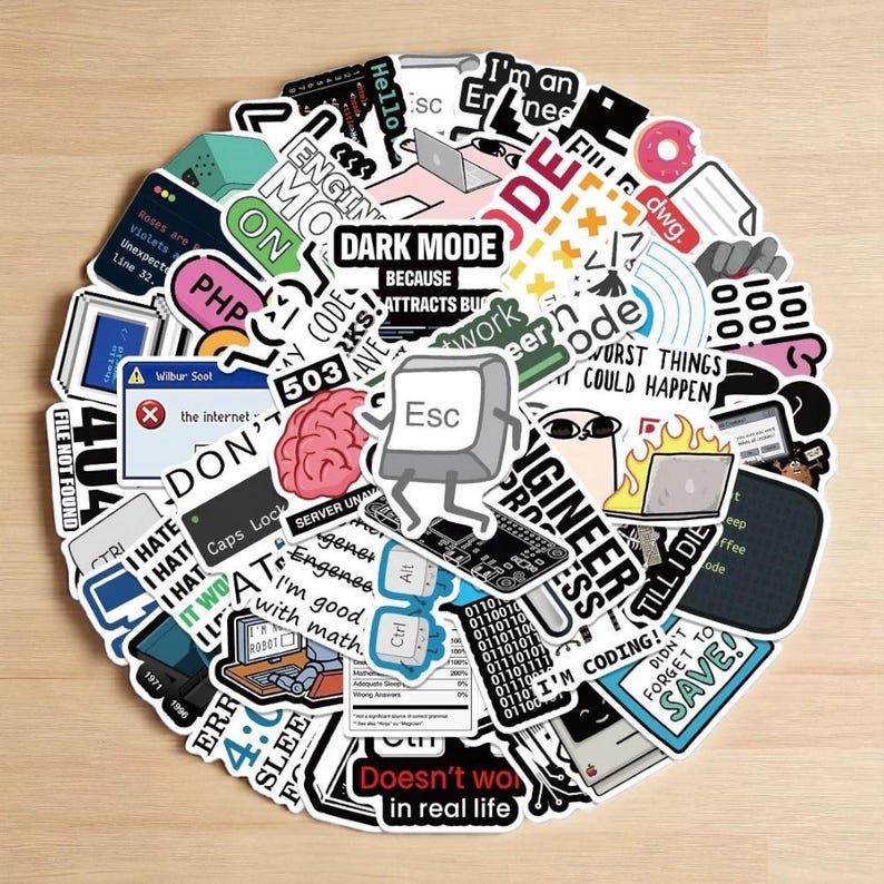 K&ouml;nnte beinhalten: Eine Sammlung bunter Aufkleber mit verschiedenen Designs zum Thema Technik und Programmierung. Die Aufkleber zeigen Texte wie "DARK MODE", "I'm good with math" und "Doesn't work in real life". Weitere Aufkleber zeigen ein Gehirn, eine Tastenkappe und einen Laptop.