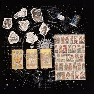 Pu&ograve; includere: Uno sfondo nero con un cerchio bianco che contiene una ruota zodiacale con costellazioni e carte dei tarocchi. Le carte sono La Ruota della Fortuna, Gli Amanti e L'Imperatrice. Il testo sulle carte &egrave; in bianco e nero. La ruota zodiacale ha i segni della Bilancia, del Sagittario, del Capricorno, dell'Acquario, dei Gemelli e del Cancro. Ci sono anche diverse piccole illustrazioni in bianco e nero di vari simboli zodiacali.