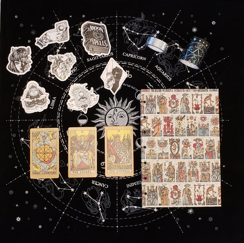 Pu&ograve; includere: Uno sfondo nero con un cerchio bianco che contiene una ruota zodiacale con costellazioni e carte dei tarocchi. Le carte sono La Ruota della Fortuna, Gli Amanti e L'Imperatrice. Il testo sulle carte &egrave; in bianco e nero. La ruota zodiacale ha i segni della Bilancia, del Sagittario, del Capricorno, dell'Acquario, dei Gemelli e del Cancro. Ci sono anche diverse piccole illustrazioni in bianco e nero di vari simboli zodiacali.
