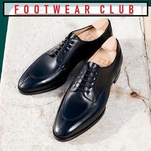 May include: Two black leather dress shoes with lace-up closures and a pointed toe. The shoes have a subtle stitching detail and are on a white textured surface. The text "FOOTWEAR CLUB" is visible at the top of the image.