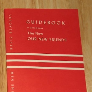 May include: Red guidebook with white text that reads "GUIDEBOOK to accompany The New OUR NEW FRIENDS" and "BASIC READERS" on the side. The book has three white stripes on the front cover.