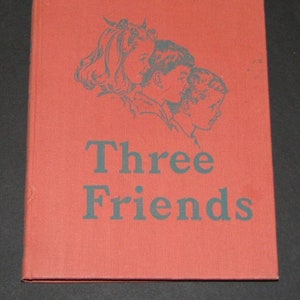 Puede incluir: Libro de tapa dura rojo con una ilustración en blanco y negro de tres niños en la portada. El título del libro es "Three Friends" en texto negro.