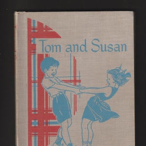 May include: A vintage book cover with a light grey background and red and blue plaid pattern. The title "Tom and Susan" is printed in blue cursive font. Two children, a boy and a girl, are depicted in blue, holding hands and smiling.