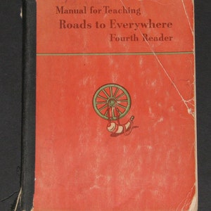 May include: Red book cover with the title "Manual for Teaching Roads to Everywhere Fourth Reader". The cover features a green spinning wheel with a white horn.