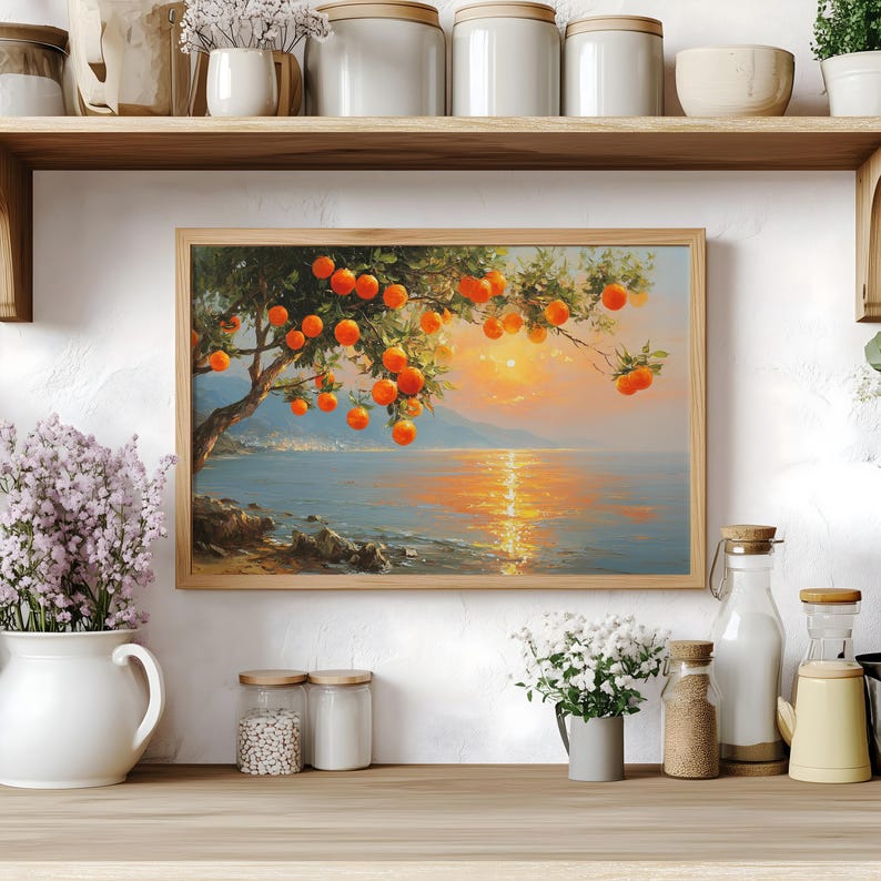 May include: A framed landscape painting depicts a tree laden with bright orange fruit, hanging over a tranquil body of water. The artwork features a sunset with golden light reflecting on the water's surface, creating a serene and warm atmosphere.
