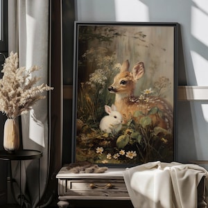 May include: A framed art print depicting a fawn and a white rabbit amidst wildflowers and foliage. The artwork has a vintage style with muted tones, creating a natural theme. The print is displayed on a wall, adding a touch of nature-inspired decor.