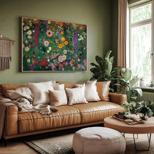 May include: A living room scene featuring a brown leather sofa adorned with white and tan pillows. A large floral painting hangs above the sofa. A round wooden coffee table and a beige ottoman complete the cozy setting.