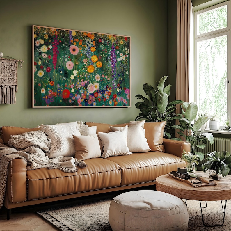 May include: A living room scene featuring a brown leather sofa adorned with white and tan pillows. A large floral painting hangs above the sofa. A round wooden coffee table and a beige ottoman complete the cozy setting.