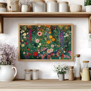 May include: A framed floral print featuring a vibrant field of colorful flowers in shades of red, pink, yellow, and purple. The artwork is set against a green background, with a wooden frame. The print is displayed on a wooden shelf.