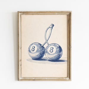 Peut inclure: Impression d'art encadrée représentant une illustration bleue et blanche de deux cerises, chacune ressemblant à une boule de billard numéro huit. L'œuvre est sur fond beige, dans un cadre en bois rustique.