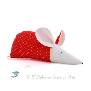 May include: A red and white stuffed mouse with white polka dots on the red fabric. The mouse has a long white snout and pink ears.