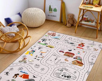 May include: A white play mat with black lines forming a road and a town. The mat features illustrations of houses, trees, cars, animals, and people. The mat is on a wooden floor in a room with a rocking chair and a side table.