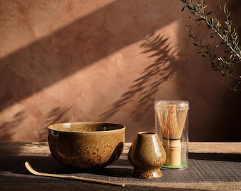 May include: A set of three ceramic nesting bowls in shades of blue, green, and white. The bowls feature a speckled glaze and a simple, modern design. The largest bowl measures approximately 8 inches in diameter.