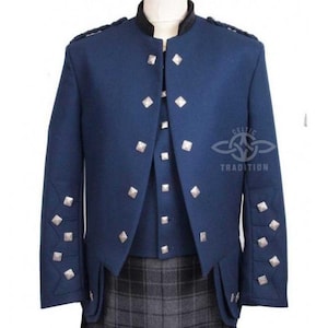Può includere: Giacca blu navy con bottoni e dettagli argentati a forma di diamante. La giacca ha un colletto alto ed è abbinata a un gilet coordinato e a un kilt a quadri grigi. Il logo Celtic Tradition è visibile.