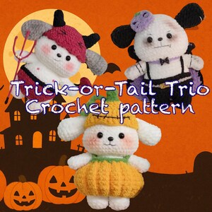 Könnte beinhalten: Ein Halloween-Bild mit drei Häkelfiguren, die als Teufel, Vampir und Kürbis verkleidet sind. Die Figuren sind weiß mit schwarzen Augen und rosa Wangen. Der Text "Trick-or-Tail Trio Crochet pattern" ist auf dem Bild zu sehen.