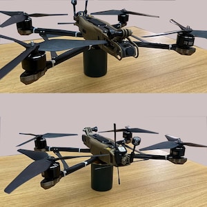 Puede incluir: Un dron negro y marrón con seis hélices y una cámara montada en la parte delantera. El dron está sentado en un cilindro negro.