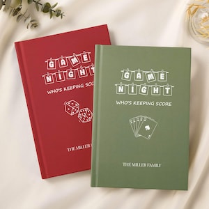 Puede incluir: Dos diarios de noche de juegos de tapa dura, uno rojo y otro verde. El diario rojo presenta gráficos de dados, mientras que el diario verde tiene gráficos de naipes. Ambos tienen el texto "GAME NIGHT" y "WHO'S KEEPING SCORE".