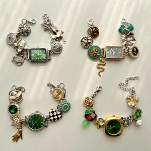 May include: Four decorative charm bracelets with watch faces. Each bracelet features a different watch face shape and colour, with green dials. The bracelets are adorned with various charms, including stars, flowers, crowns, and other decorative elements.