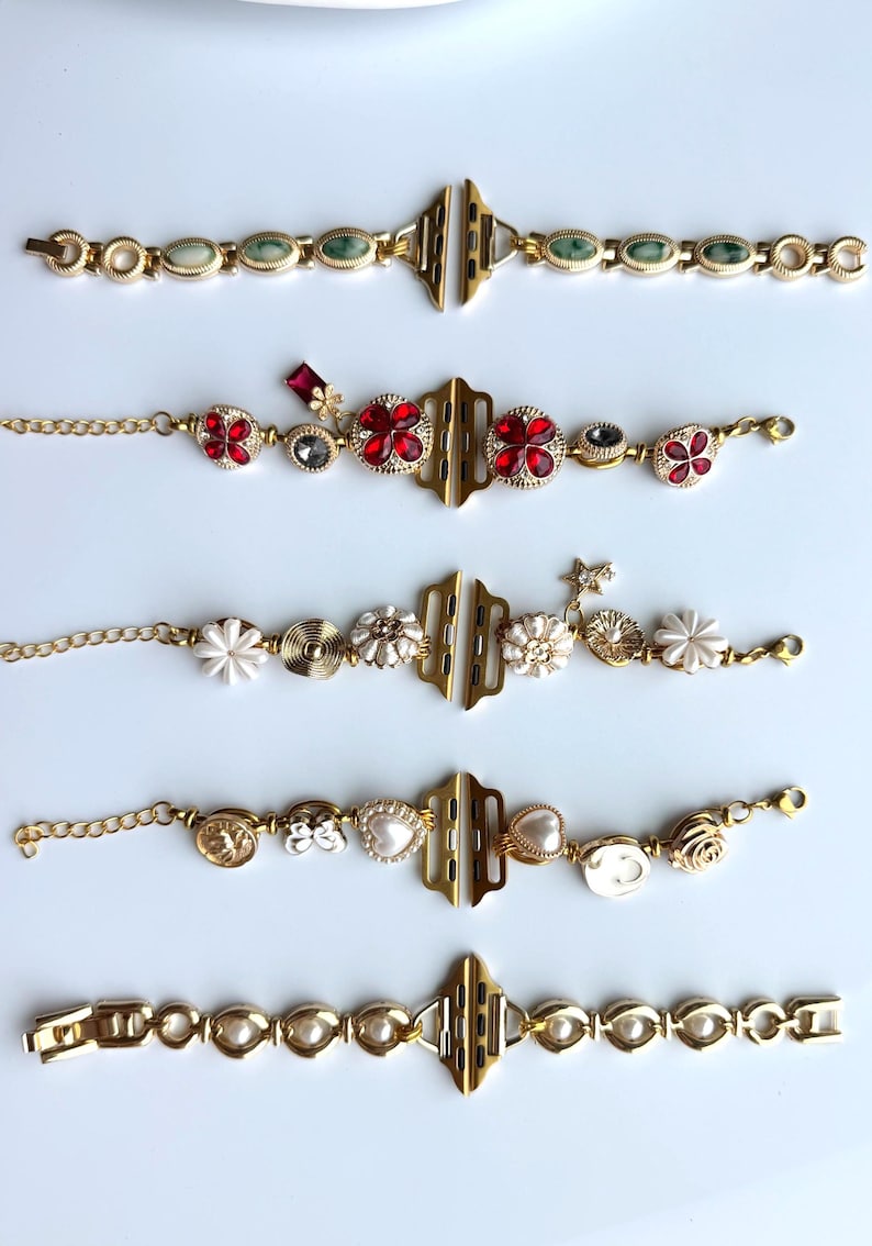 May include: Gold-toned watch bands with various decorative elements. Designs include bands with green stones, red floral accents, white flowers, pearls, and other embellishments. Each band features a gold clasp and chain.