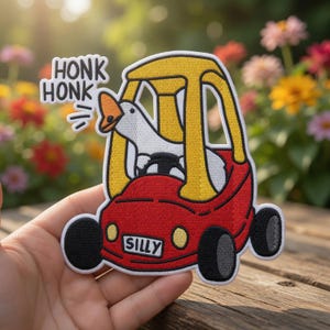 May include: Embroidered patch featuring a white goose driving a red toy car with a yellow top. The patch has the words "HONK HONK" and "SILLY". The car has black wheels and headlights.