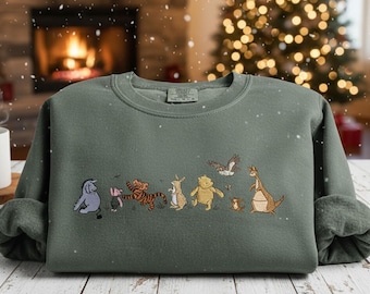 May include: A sage green sweatshirt featuring embroidered cartoon characters. The design includes a blue donkey, a pink pig, a tiger, a rabbit, a bear, a small brown animal, a kangaroo, and a bird. The sweatshirt has a crew neck and long sleeves.