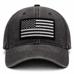 Könnte beinhalten: Eine anthrazitfarbene Baseballkappe mit einem Aufnäher mit der amerikanischen Flagge. Das Flaggen-Design hat weiße Streifen und Sterne auf schwarzem Hintergrund. Die Kappe hat einen gebogenen Schirm und einen Knopf oben.