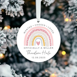Könnte beinhalten: Runder, weißer Weihnachtsschmuck mit einem pastellfarbenen Regenbogen-Design. Der Schmuck trägt die Worte "WANTED, CHOSEN, LOVED" am oberen Rand. Unter dem Regenbogen steht der Text "OFFICIALLY A MILLER" sowie ein Name und ein Datum.