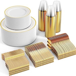 May include: A collection of disposable party supplies, including stacks of white plates with gold rims, clear plastic cups with gold bases, and stacks of gold-colored plastic cutlery. The items are arranged on a white surface.