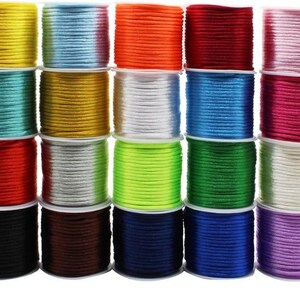 May include: A collection of colorful spools of cord in various shades, including yellow, blue, orange, red, and pink. The cords are neatly wound on white spools, creating a visually appealing display. Ideal for crafting and jewelry making.