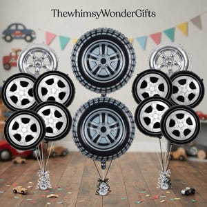 May include: A collection of foil balloons shaped like black and silver car tires and metallic silver wheel rims. The balloons are arranged in three clusters, with the text ThewhimsyWonderGifts displayed at the top of the image.