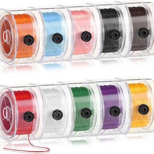May include: A set of colorful spools of thread in clear plastic containers. The thread colors include orange, blue, pink, black, brown, red, white, green, purple, and yellow. Each spool has a black center and is neatly wound.