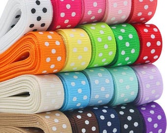 Puede incluir: Una colección de cintas de lunares de colores, incluyendo rosa, rojo, verde y azul. Cada cinta está enrollada, mostrando el patrón de lunares blancos. Ideales para manualidades y envolver regalos. Se muestra una variedad de colores.