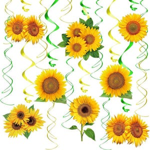 May include: A vibrant arrangement of sunflowers with bright yellow petals and dark brown centers. Green leaves and stems are visible. The sunflowers are interspersed with green and gold curling ribbons against a white background.