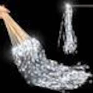 May include: A hand pouring water from a pitcher into a clear glass. The water is flowing in a stream and splashing into the glass.